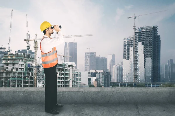 Arquiteto olhando para o canteiro de obras com binocular — Fotografia de Stock