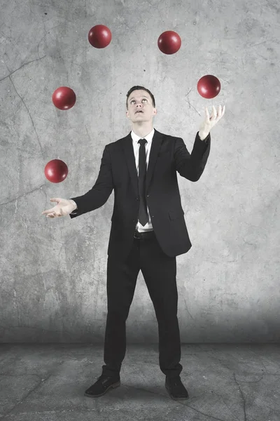 Amerikanischer Geschäftsmann jongliert mit roten Bällen — Stockfoto