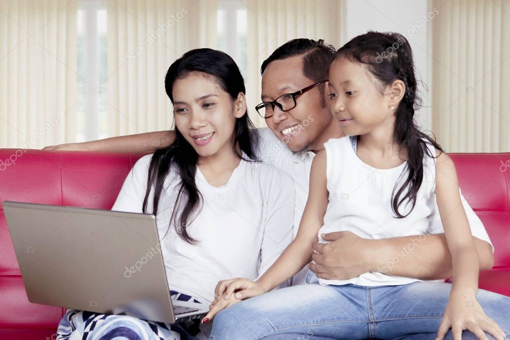 Parents and child using a laptop together