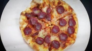 Tablonun üst iplik sonra ahşap plaka üzerinde dilim biberli pizza alarak el yakın çekim