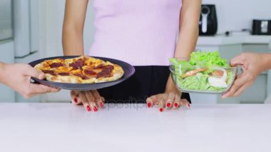 Diyet kavramı. Bilinmeyen kadın el pizza plakasını çıkarma ve salata bir kase yemek için tercih jest. 4 k çözünürlükte vurdu