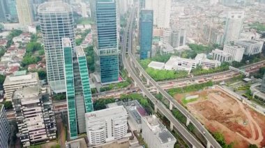 Jakarta - Endonezya. 22 Aralık 2017: Otoyol ve merkezi iş bölgesi içinde iki köprü ile gökdelenlerin güzel havadan görünümü. 4 k çözünürlükte vurdu