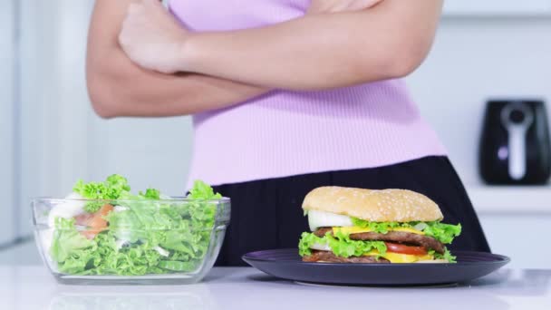 节食概念 不知名的女人的手 拒绝一碗沙拉和选择吃一盘汉堡包 分辨率拍摄 — 图库视频影像
