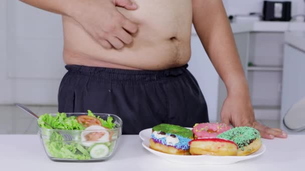 节食概念 未知的超重男子决定选择和吃一碗沙拉比甜甜圈 分辨率拍摄 — 图库视频影像