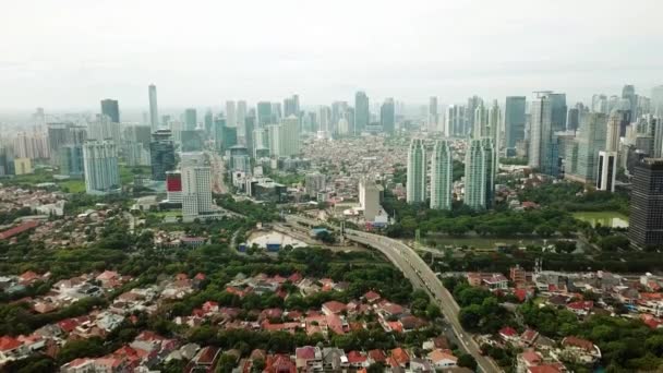 美丽的空中拍摄的拥挤的住宅与摩天大楼背景从一架无人驾驶飞机向后飞在雅加达 印度尼西亚 分辨率拍摄 — 图库视频影像