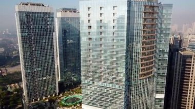 Jakarta - Endonezya. 26 Aralık 2017: Soldan sağa, bir dron uçan Kuningan Cbd Jakarta cam pencerelerle gökdelenlerin havadan görünümü vurdu içinde 4 k çözünürlük