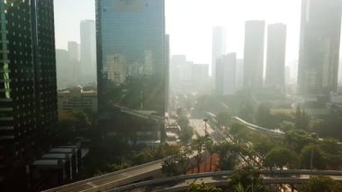 Jakarta - Endonezya. 26 Aralık 2017: Hava görüntüleri üzerinden tam şehir merkezinde, Jakarta sola doğru uçan bir uçağın puslu sabah içinde gökdelenler vurdu içinde 4 k çözünürlük