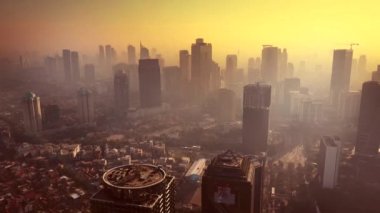 Jakarta - Endonezya. 26 Aralık 2017: Turuncu gökyüzü ve sis veya duman ile alacakaranlıkta işyeri binalarının Jakarta hava manzara. 4 k çözünürlükte vurdu