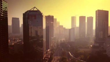 Jakarta - Endonezya. 26 Aralık 2017: Güzel Jakarta cityscape gökdelenler ve turuncu gökyüzü ile gece karanlığında ileri uçan bir dron üzerinden. 4 k çözünürlükte vurdu