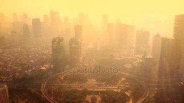 Jakarta - Endonezya. 26 Aralık 2017: Jakarta bir yol kavşağı ileri gökdelenler görünümü ve sis ile gece karanlığında uçan bir uçağın üzerinden görünümü robot. 4 k çözünürlükte vurdu