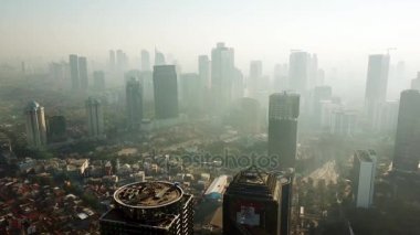 Jakarta - Endonezya. 26 Aralık 2017: Kuş aşağı sis ve gökdelenler görünümü ile uçan bir uçağın puslu sabah Jakarta cityscape bakış. 4 k çözünürlükte vurdu