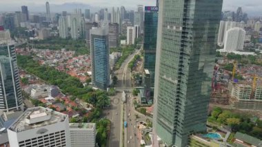 Jakarta - Endonezya. 28 Aralık 2017: Jakarta şehir panorama gökdelen ve yukarı doğru uçan bir dron karayolu ile vurdu içinde 4 k çözünürlük