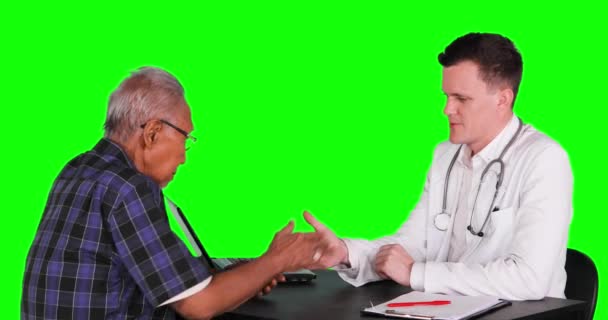 年轻的白种医生与年老的男性病人在体检后握手 在4K 分辨率下用绿色屏幕背景拍摄 — 图库视频影像