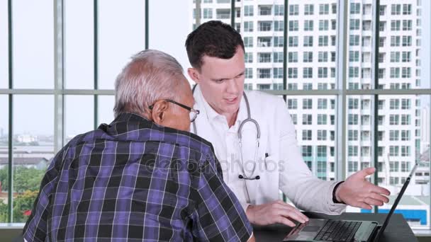 Jonge Blanke Dokter Legt Checkup Resultaat Zijn Oudere Patiënt Met — Stockvideo