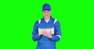 Boş ekran dijital tablet bilgisayarınızla gösterilen ve mavi üniforma beyaz araba tamircisi vurdu 4 k çözünürlüklü yeşil ekran arka planı ile