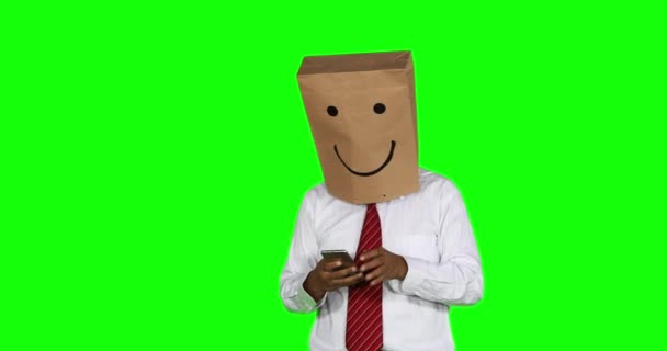 Selfie 携帯電話で写真を撮って 頭に紙袋を持つ正体不明実業家 グリーン スクリーンの背景を持つ 解像度で撮影します — ストック動画