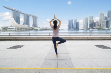 Pratik Yoga esplanade Köprüsü'nde genç kadın