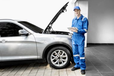 Kırık araba ve tablet ile erkek makinist