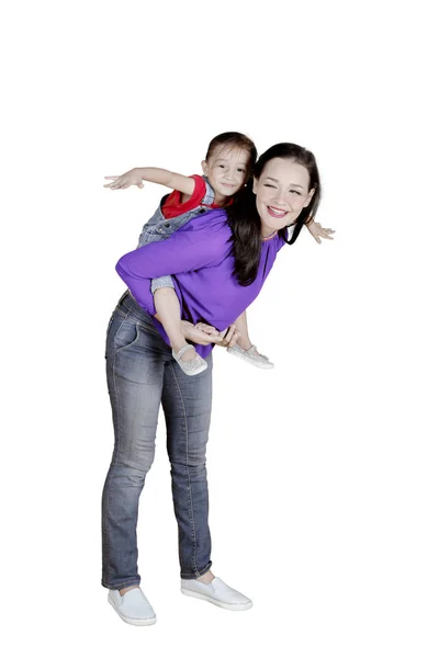 Mãe dando um passeio de piggyback sua filha — Fotografia de Stock