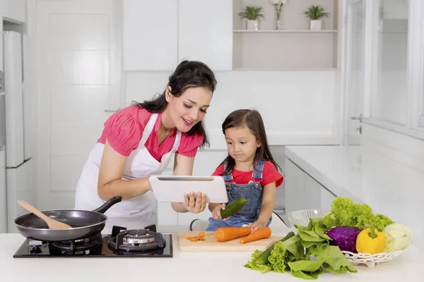 Mère et enfant utilisant une tablette dans la cuisine — Photo