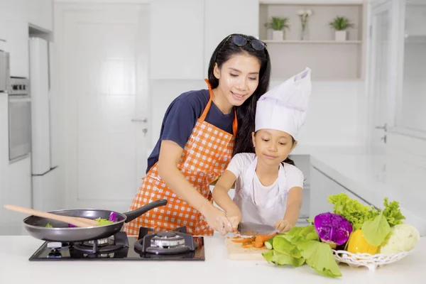 어린 소녀는 그녀의 어머니와 함께 요리를 배운다합니다 — 스톡 사진