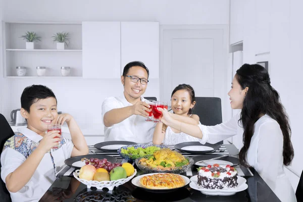 Pequeño niño tostando vasos con su familia — Foto de Stock