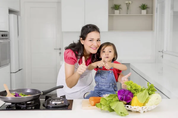 Kind en moeder tonen Ok teken in keuken — Stockfoto