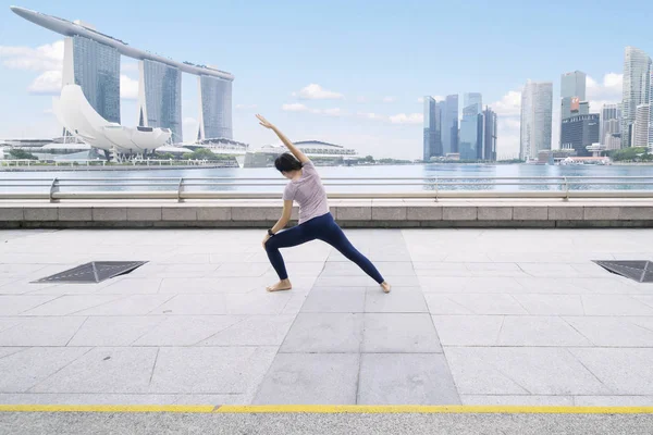 Mulher asiática fazendo alongamento na ponte de esplanada — Fotografia de Stock