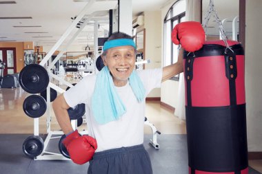 Bir boks torbayla yaşlı erkek ayakta