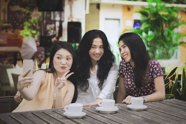 Trois femmes prenant des photos dans le café — Photo