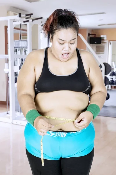 Mujer conmocionada midiendo su vientre gordo — Foto de Stock
