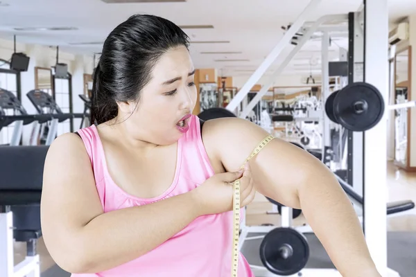 Mujer con sobrepeso midiendo su bíceps — Foto de Stock