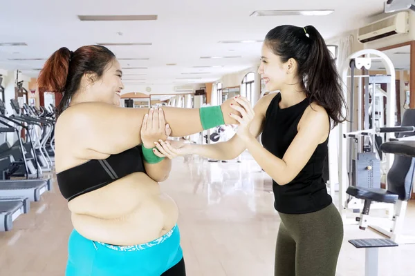 Femme en surpoids faisant un étirement avec son instructeur — Photo