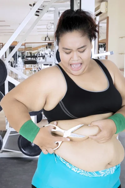 Mujer con sobrepeso cortando su vientre en el centro de gimnasio — Foto de Stock