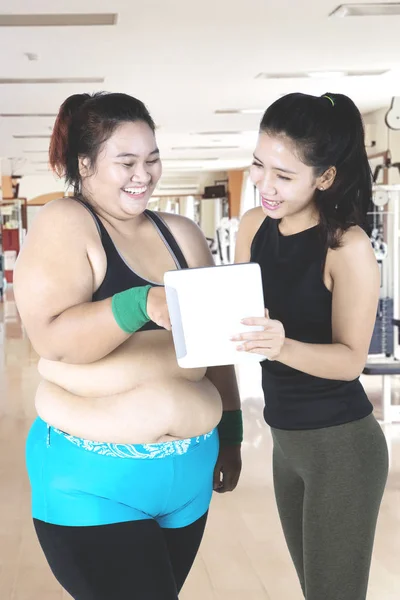 Femme obèse avec formateur et tablette numérique — Photo