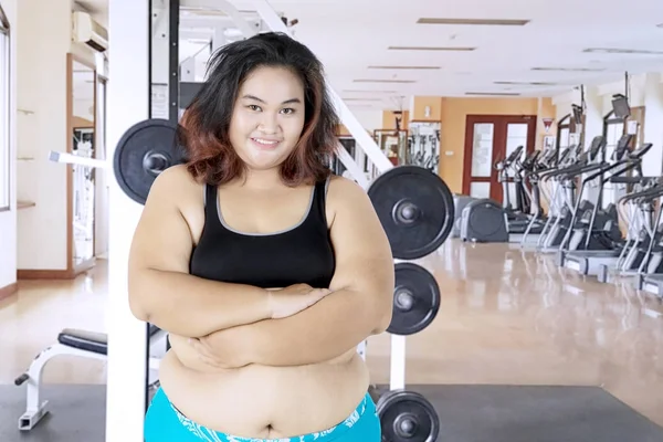 Obese woman folded her arms in gym center