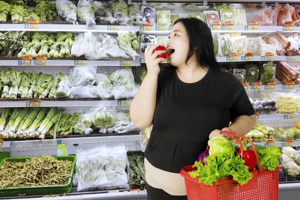 Mujer obesa comiendo una manzana orgánica — Foto de Stock