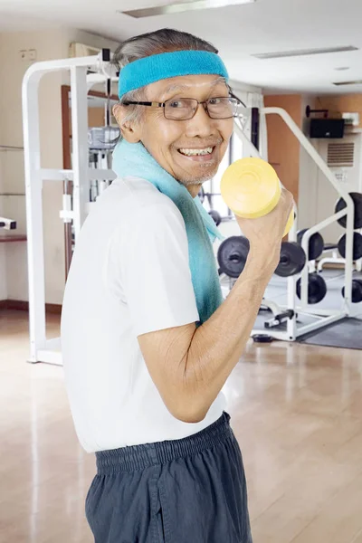 Happy elderly man exercising with a dumbbell — Stock Photo, Image