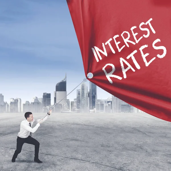 European businessman pulls text of interest rates — Stock Photo, Image