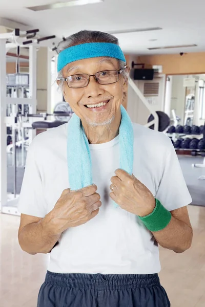 Oudere man permanent in het fitnesscenter — Stockfoto