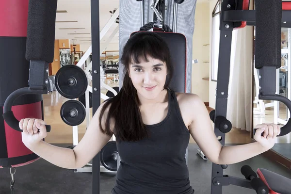 Mujer árabe haciendo ejercicio con una máquina de pesas — Foto de Stock