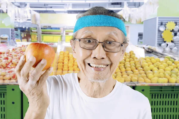Homme âgé montrant une pomme saine — Photo