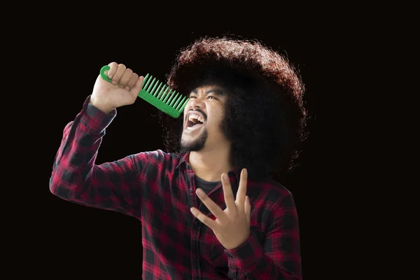 African man singing with a hair comb — Stock Photo, Image