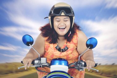 Bir scooter sürme genç şişman kadın