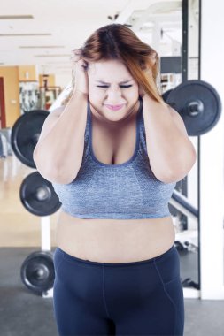 Obez kadın fitness merkezinde depresif görünüyor