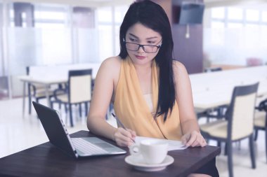 Kadın girişimci bir rapor kafede yapar.