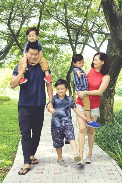 Junge Familie spaziert gemeinsam durch den Park — Stockfoto