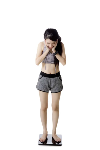 Chica sorprendida de pie en la balanza de pesaje — Foto de Stock