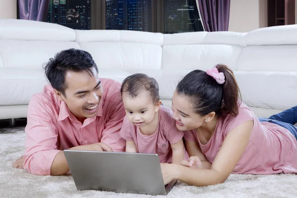 Pais com bebê bonito usando um laptop — Fotografia de Stock