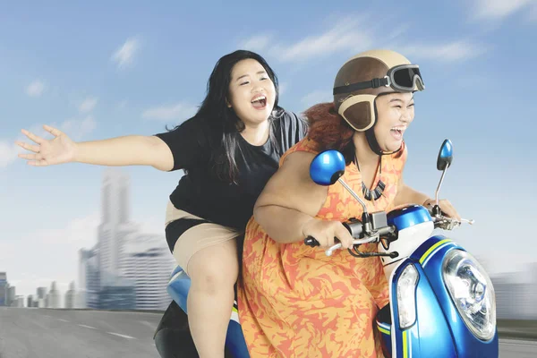 Zwaarlijvige vrouwen genieten van hun reis met scooter — Stockfoto
